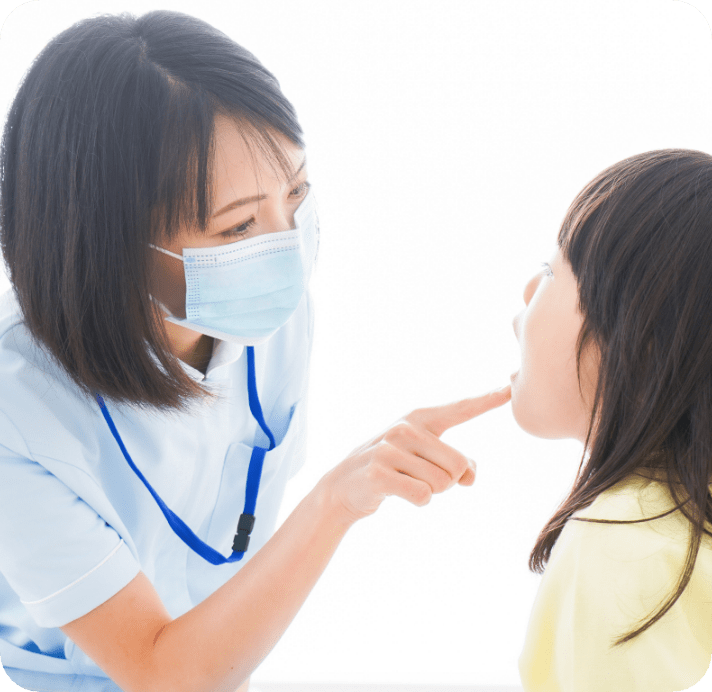 女性歯科衛生士が女の子のお口の中を診ている写真