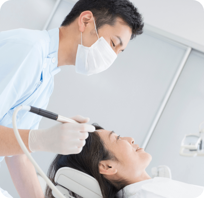 男性歯科医が女性の患者の治療をしている写真