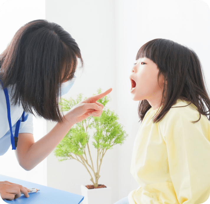 女の子がお口を開けて女性の歯科衛生士に見てもらっている写真